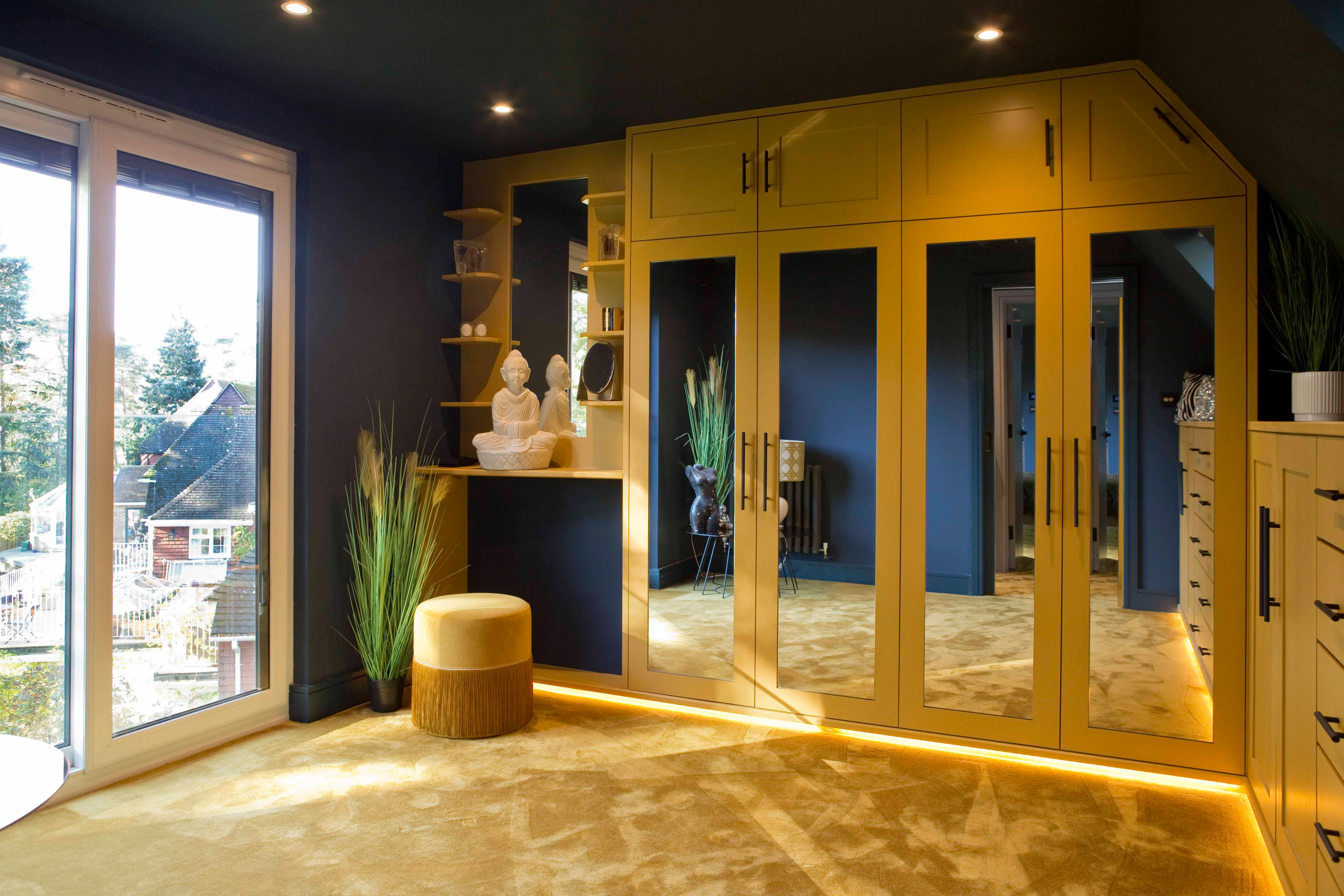 a room with a large mirror and a yellow cabinet