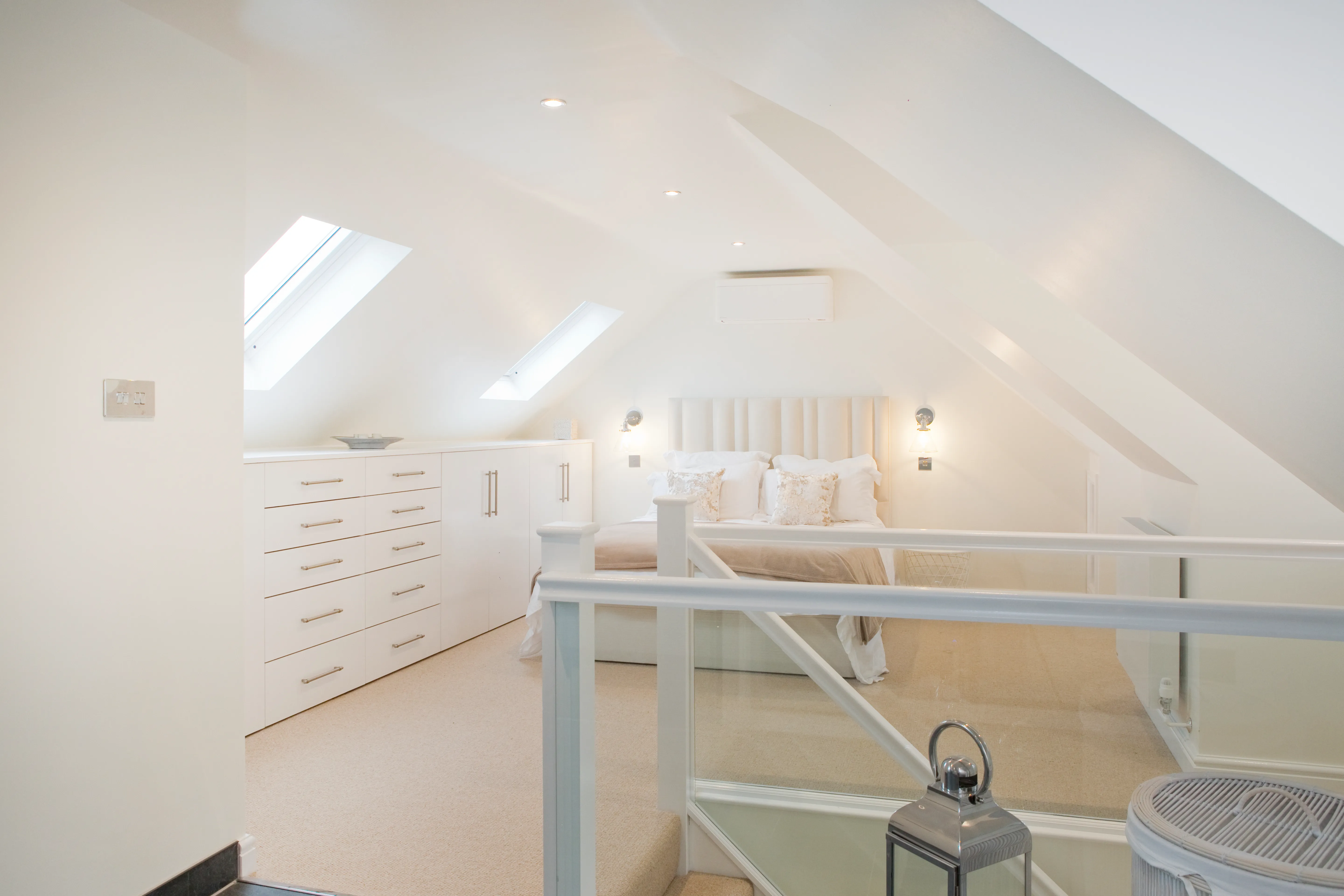 a bedroom with a white bed and a white dresser